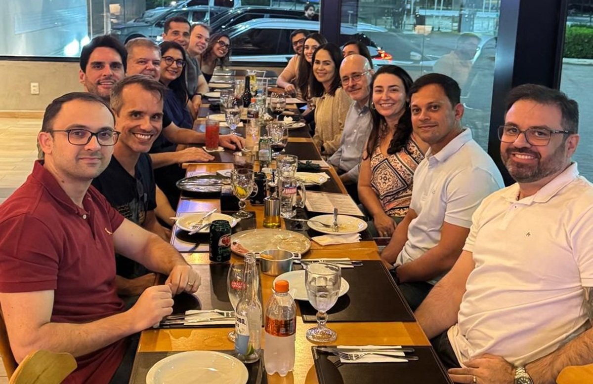 Fotos dos juízes e juízas em mesa de restaurante, sorrindo.