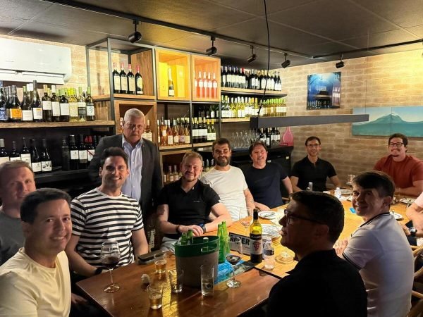 Juízes pais da AMEPE estão sentados na mesa, sorrindo para a foto.